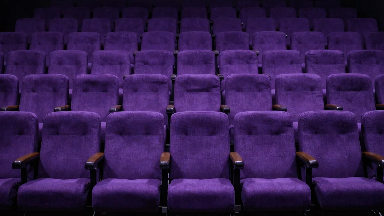 Cinema escuro com poltronas vazias e feixe de projeção suave, atm